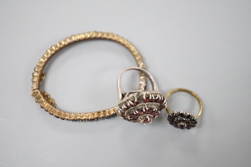 A Victorian garnet cluster set gilt metal dress ring, one other garnet set cluster ring and a garnet paste set hinged bangle.